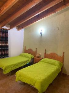 2 letti in una camera con lenzuola verdi di Casa Alta 14 B a Palanques