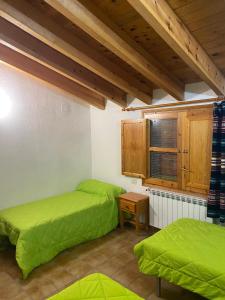 2 letti in una camera con lenzuola verdi di Casa Alta 14 B a Palanques