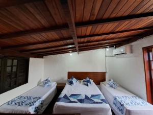 Dos camas en una habitación con techo de madera. en Lua Chalés 14 chalés equipados com churrasqueira individua , piscina e hidro incluindo café da manhã servido no quarto , roupa de cama, toalhas de banho e de praia a apenas 600 metros da praia de Maresias, en Maresias 94 fotos más