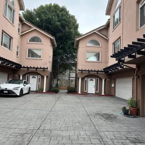 un'auto bianca parcheggiata di fronte a due edifici di Tranquility home a Hayward