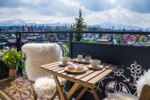 un tavolo su un balcone con cibo di Pensjonat Litworówka Wellness&SPA a Poronin