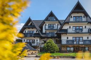 un grande edificio bianco con tetto nero di Pensjonat Litworówka Wellness&SPA a Poronin