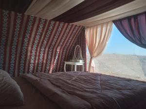 a bedroom with a bed and a window at Mujib Castle Gate Camp in Dhībān +88 photos