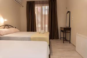 a hotel room with two beds and a window at Studios for rent Hermanos in Stavros