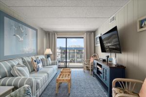 a living room with a couch and a tv at 2 Bedroom Ocean Block Condo, Steps to the Beach! in Ocean City