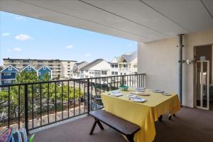 a table with a yellow table cloth on a balcony at 2 Bedroom Ocean Block Condo, Steps to the Beach! in Ocean City