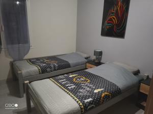 2 aparte bedden in een kamer met een foto aan de muur bij Castorette, au calme, petit déjeuner compris in Mimizan