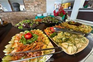 ein Buffet mit vielen verschiedenen Speisen auf einem Tisch in der Unterkunft Hotel Fazenda Monte Castelo in Bezerros