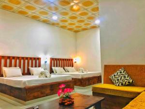 a hotel room with two beds and a table at Clay House in Udawalawe