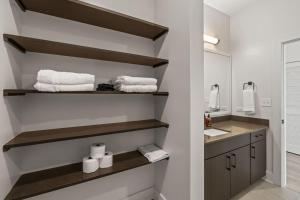 a bathroom with shelves and a sink and a mirror at Elegant 1BR Walkable to Dining, Pool + Gym in Tampa