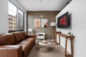 een woonkamer met een bank en een tafel bij Premium Downtown High-Rise Condo with Pool, Parking, Gym in Indianapolis