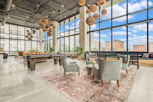 een grote kamer met een tafeltennistafel en stoelen bij Premium Downtown High-Rise Condo with Pool, Parking, Gym in Indianapolis