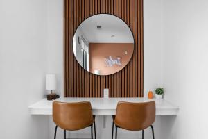 een spiegel aan de muur boven een kaptafel met twee stoelen bij The Indy Suite High-Rise Condo with Pool, Gym, Parking in Indianapolis +22 foto's