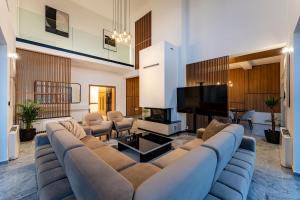 un soggiorno con un grande divano e una TV a schermo piatto di Villa Prestige a Pag