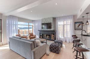 a living room with a couch and a fireplace at Altitude Ski-in Out at Resort with Private Hottub in Mont-Tremblant