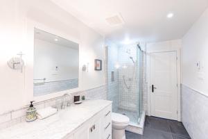 a white bathroom with a sink and a shower at Altitude Ski-in Out at Resort with Private Hottub in Mont-Tremblant +13 photos