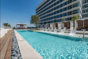 a swimming pool with chairs and a building at Chic Channelside Getaway in DT | Close to DT! in Tampa