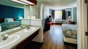 a bathroom with a sink and a bedroom with a bed at Studio 6 Suites Portland OR I-5 OHSU in Portland +87 photos