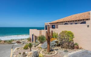 a house with a cactus in front of the ocean at Casita Alegre - Clifftop Stay Above Knight Beach in Port Elliot