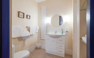 a white bathroom with a sink and a mirror at Casita Alegre - Clifftop Stay Above Knight Beach in Port Elliot +20 photos