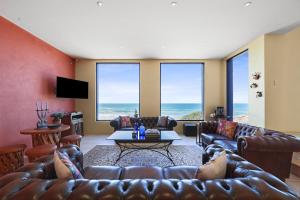 a living room with a couch and a table at Casita Alegre - Clifftop Stay Above Knight Beach in Port Elliot