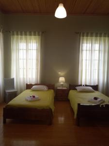 une chambre avec deux lits et deux fenêtres dans l'établissement Σπίτι στο Χωριό - Les campagnards, à Rodhodháfni 21 autres photos