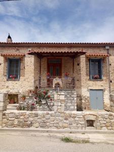 une maison en pierre avec une porte rouge et des fenêtres dans l'établissement Σπίτι στο Χωριό - Les campagnards, à Rodhodháfni