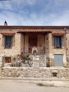 une maison en pierre avec des fleurs à l'avant dans l'établissement Σπίτι στο Χωριό - Les campagnards, à Rodhodháfni