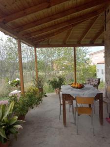 une table et des chaises sous une pergola en bois dans l'établissement Σπίτι στο Χωριό - Les campagnards, à Rodhodháfni