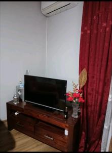 una TV a schermo piatto seduta sopra un centro di intrattenimento in legno di Stan na dan Ugljevik Centar a Ugljevik