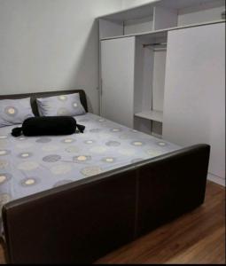 un letto in una piccola stanza con un cuscino nero sopra di Stan na dan Ugljevik Centar a Ugljevik