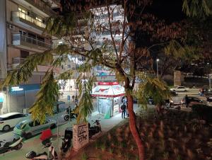 a city street at night with a tree and cars at Molly Downtown Thessaloniki in Thessaloniki