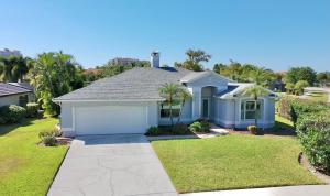 een wit huis met een garage in een tuin bij Villa Charming in Cape Coral