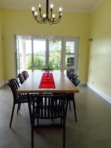 een eettafel met stoelen en een kroonluchter bij Holland Manor in Durban +13 foto's