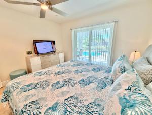 een slaapkamer met een bed en een flatscreen-tv bij Villa Charming in Cape Coral +15 foto's