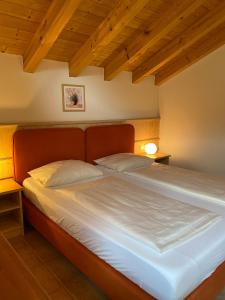 een groot bed in een kamer met houten plafonds bij 3-Raum-Maisonette-Wohnung Sonnenblume in Bolsterlang