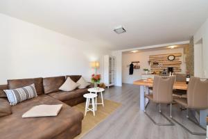 een woonkamer en keuken met een bank en een tafel bij Haus Ideal 3-Raum-Wohnung edelWEISS in Fischen +6 foto's