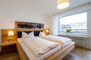 a bedroom with a large bed with a large window at Haus Ideal 2-Raum-Wohnung Rosenrot in Fischen