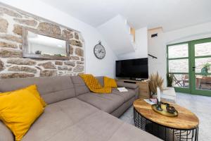 ein Wohnzimmer mit einer Couch und einer Steinwand in der Unterkunft Villa Agora - Betina in Betina