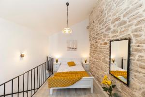 ein Schlafzimmer mit einem Bett und einem Spiegel an der Wand in der Unterkunft Villa Agora - Betina in Betina