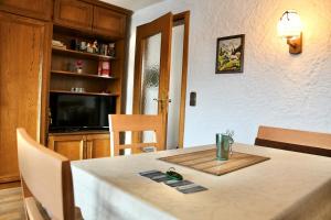 a dining room with a table and a television at Ferienwohnung "Am Dorfbach" mit Sommer Hörnerbahnen kostenlos in Bolsterlang
