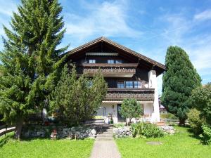 a large house with trees in front of it at Ferienwohnung "Am Dorfbach" mit Sommer Hörnerbahnen kostenlos in Bolsterlang