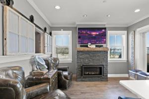 a living room with a fireplace and a tv at Modern Beachfront Escape - Steps from Ferry - Deck in Provincetown