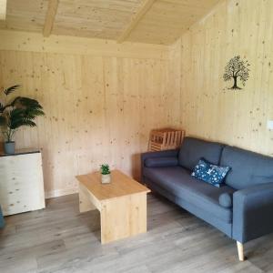 a living room with a blue couch and a table at ZEcamping 3 étoiles piscine chauffée in Vendoire