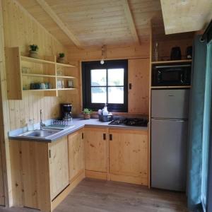 a small kitchen with a sink and a stove at ZEcamping 3 étoiles piscine chauffée in Vendoire
