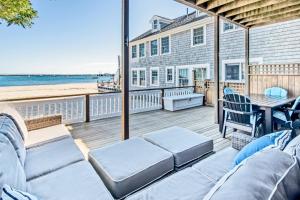 a patio with a table and chairs and the beach at Modern Beachfront Escape - Steps from Ferry - Deck in Provincetown