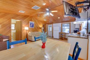 una sala da pranzo e un soggiorno con soffitto in legno. di Fish, Boat and Explore Cross Creek Cabin with Dock! a Cross Creek