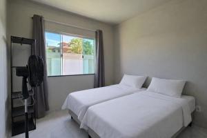 a bedroom with two beds and a window at Casa privativa em Itaúna in Saquarema +19 photos