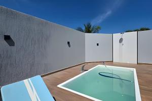 a swimming pool on a patio with a wall at Casa privativa em Itaúna in Saquarema