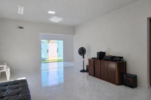 a living room with a couch and a fan at Casa privativa em Itaúna in Saquarema